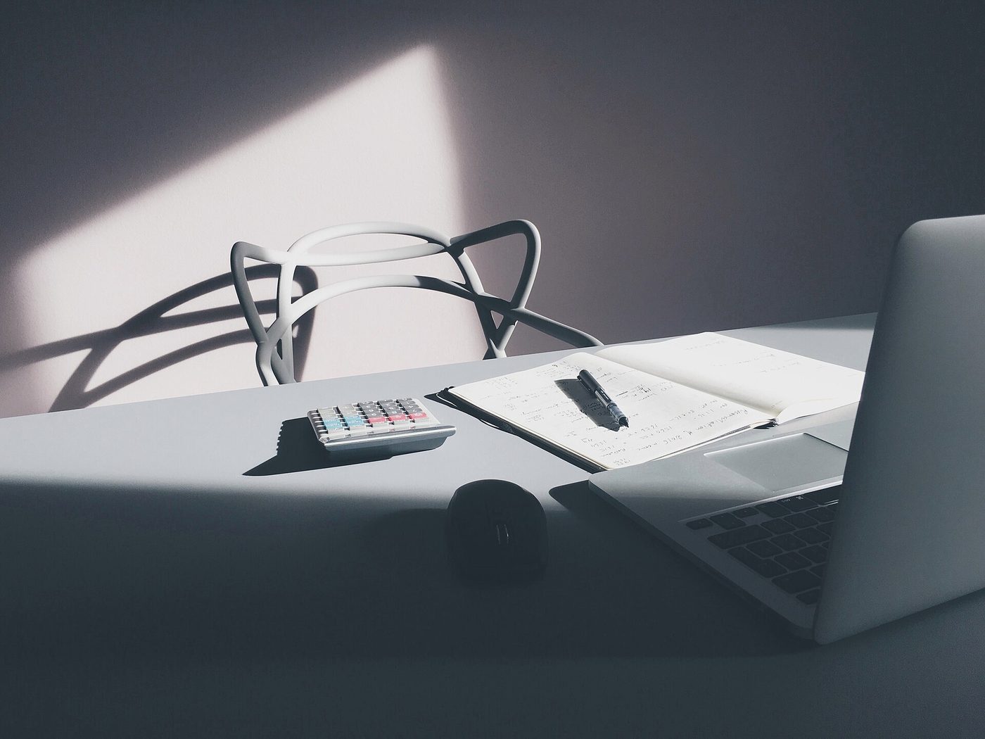 Desk with a laptop, calculator and printed financial documents laid out for planning